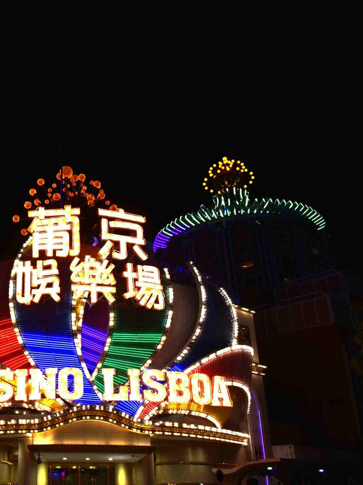 夜间点亮的建筑立面，暖黄灯串勾出弧形轮廓